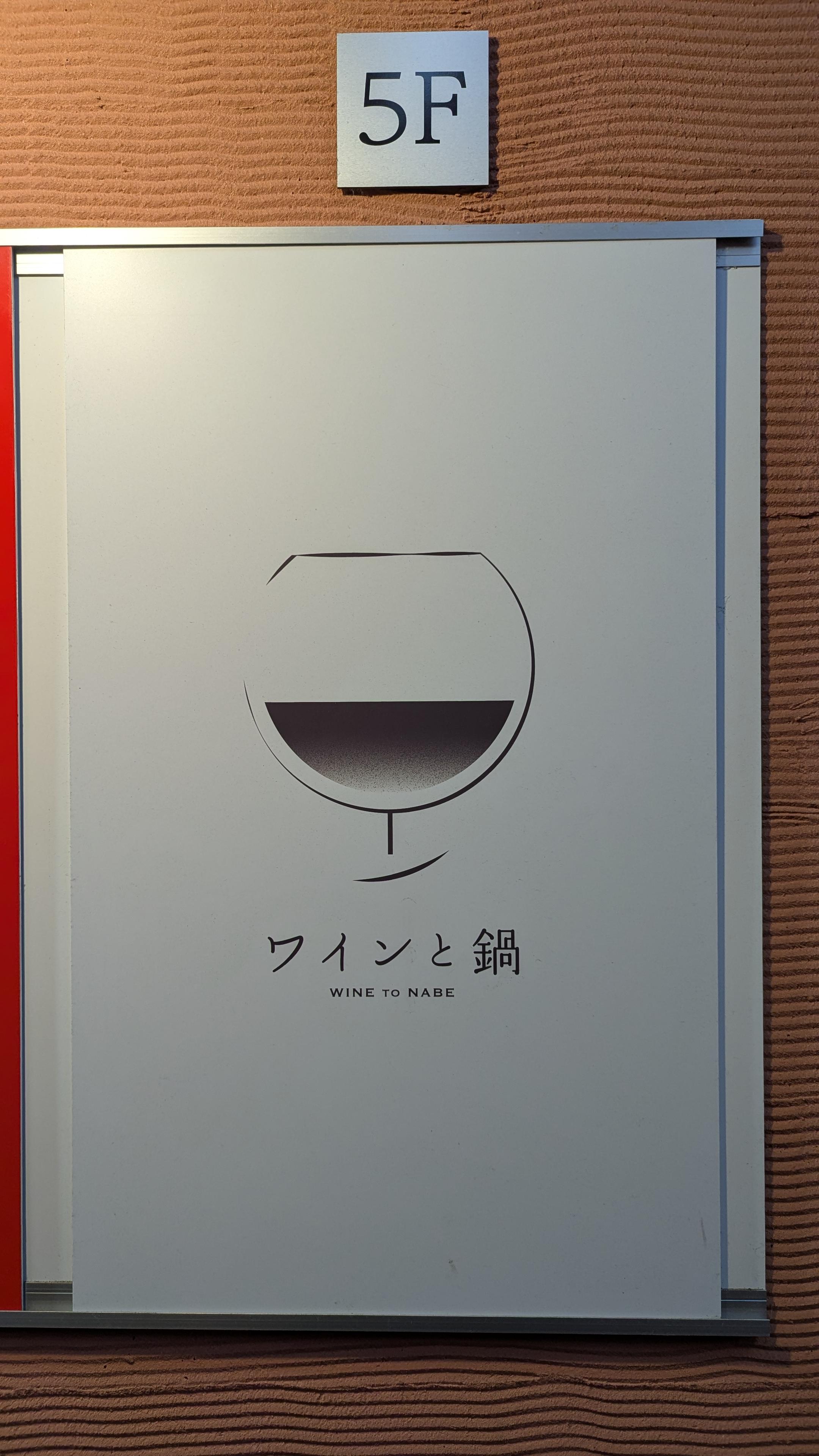 ワインと鍋の看板。5階にあることが示されている。